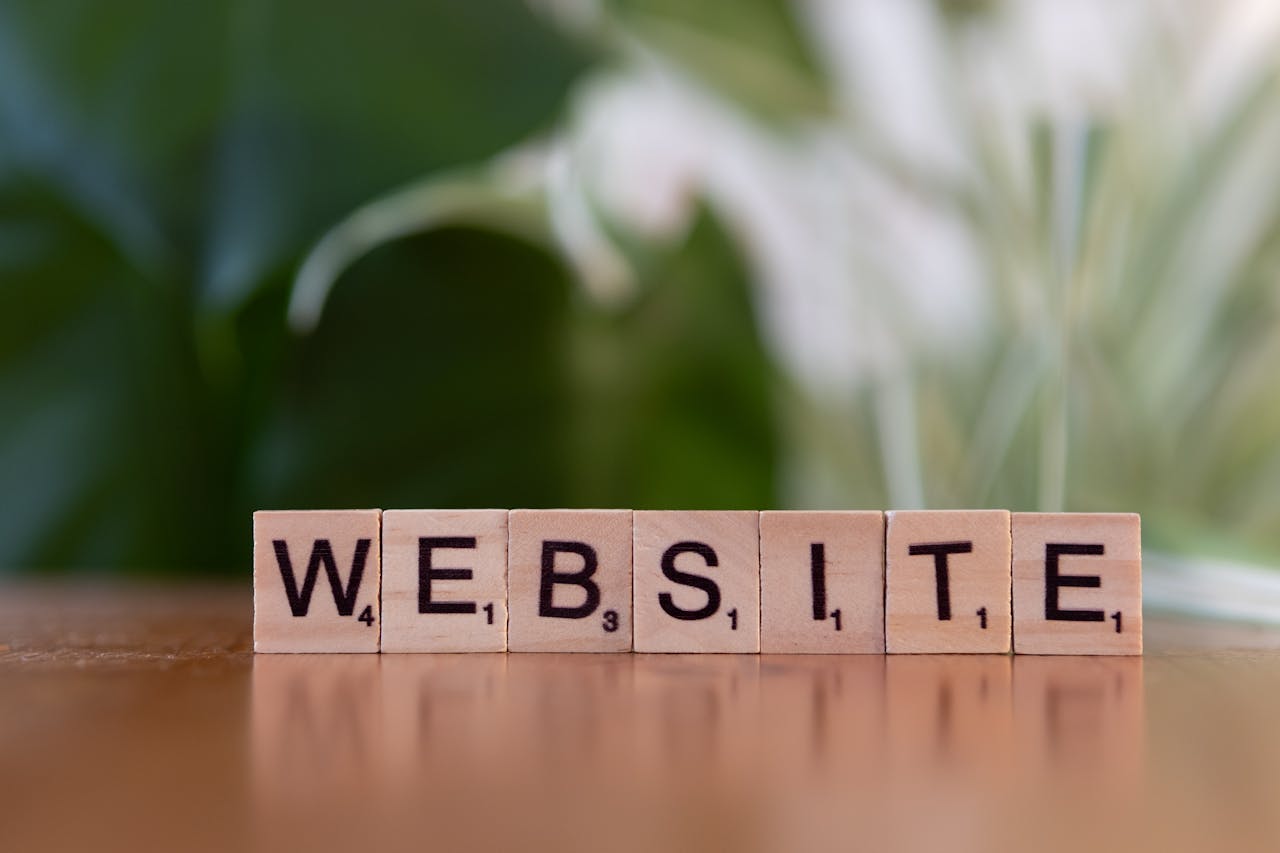 Scrabble tiles on a wooden surface forming the word 'Website', symbolizing digital communication.